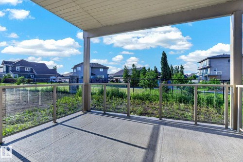 Covered concrete patio with glass panel railing and support columns - 3926 41 Avenue, Beaumont, AB - Outdoor With Balcony With Exterior