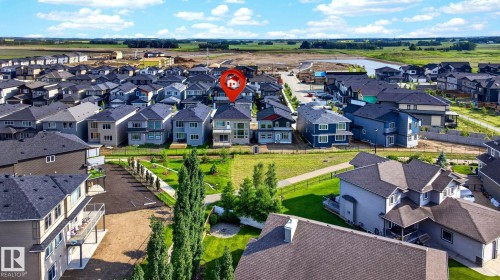 Aerial perspective showcasing a developed residential neighborhood with a variety of multi-story homes featuring dark shingle roofs and diverse siding colors - 3926 41 Avenue, Beaumont, AB - Outdoor With View