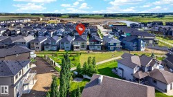 Aerial perspective showcasing a developed residential neighborhood with a variety of multi-story homes featuring dark shingle roofs and diverse siding colors - 