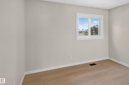 Light wood-finish flooring, neutral wall paint, and white trim - 175 Centennial Crest Nw, Edmonton, AB - Indoor Photo Showing Other Room