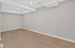 Recessed lighting, wood-finish flooring, light gray walls, and white trim - 