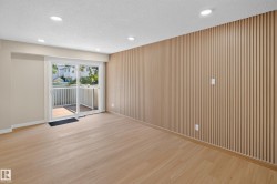 Recessed lighting, wood-finish flooring, accent wall with vertical paneling, sliding glass door, and private balcony - 