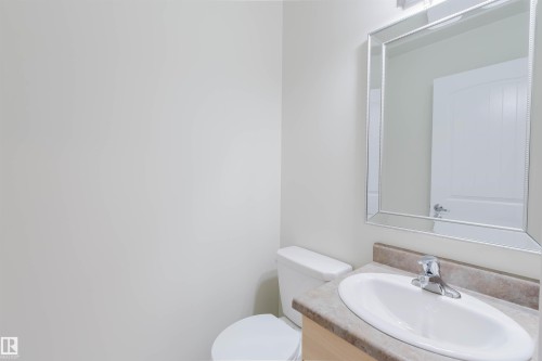 Vanity with integrated sink, chrome faucet, and framed mirror - #2 13215 153 Av Nw, Edmonton, AB - Indoor Photo Showing Bathroom