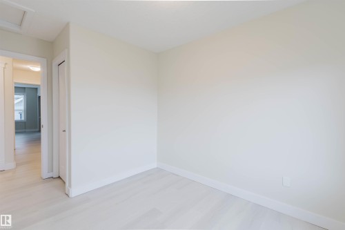 Neutral wall finishes with crisp white trim, wood-finish flooring, and recessed ceiling lighting - #2 13215 153 Av Nw, Edmonton, AB - Indoor Photo Showing Other Room