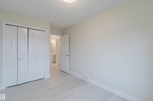 Light wood-finish flooring, white walls, and bright overhead lighting - #2 13215 153 Av Nw, Edmonton, AB - Indoor Photo Showing Other Room