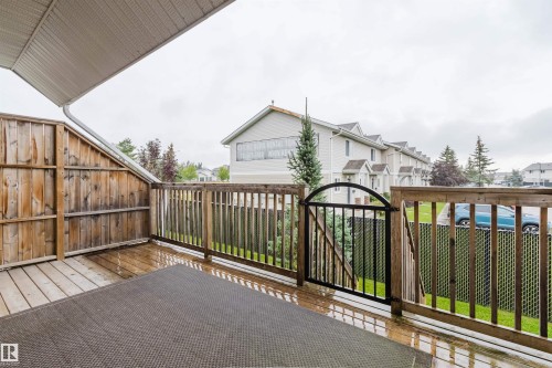 Wood deck with a metal gate and slatted wood fencing - #2 13215 153 Av Nw, Edmonton, AB - Outdoor With Exterior