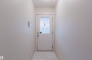 Entryway featuring a white door with decorative glass inserts, white trim, and light-toned tile flooring - #2 13215 153 Av Nw, Edmonton, AB  - Indoor Photo Showing Other Room 