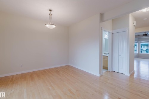 Hardwood flooring, neutral wall tones, semi-flush mount light fixture, interior bi-fold door - #2 13215 153 Av Nw, Edmonton, AB - Indoor Photo Showing Other Room