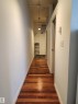Wood-finish flooring leading to an entryway with dark tile - #1002 10024 Jasper Av Nw, Edmonton, AB 