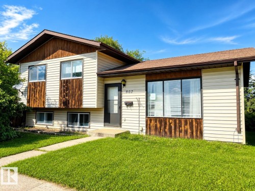 Split-level residence featuring light-colored siding and dark wood-tone paneling accents - 802 16 Avenue, Cold Lake, AB - Outdoor
