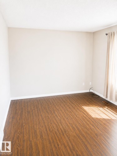 Wood-finish flooring with neutral wall paint and white trim - 802 16 Avenue, Cold Lake, AB - Indoor Photo Showing Other Room