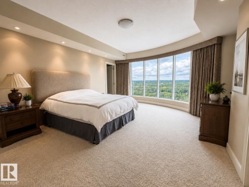 Curved window wall, recessed lighting, wall-to-wall carpeting, upholstered headboard, and privacy drapes - #1201 10035 Saskatchewan Dr Nw, Edmonton, AB - Indoor Photo Showing Bedroom