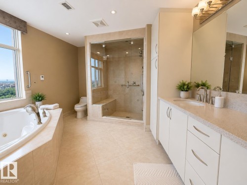 Dual vanity with integrated sinks, a walk-in shower with a built-in bench, a jetted soaking tub, tiled flooring, and recessed lighting - #1201 10035 Saskatchewan Dr Nw, Edmonton, AB - Indoor Photo Showing Bathroom