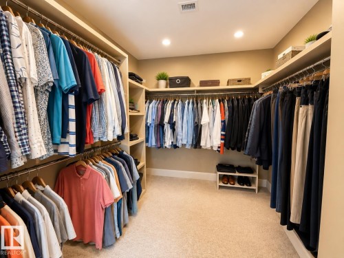 Walk-in closet featuring built-in shelving, hanging rods, recessed lighting, and carpet flooring - #1201 10035 Saskatchewan Dr Nw, Edmonton, AB - Indoor With Storage