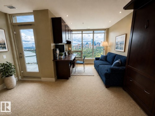 Light beige carpeting with dark wood-finish built-in cabinetry, an integrated desk, and floor-to-ceiling windows - #1201 10035 Saskatchewan Dr Nw, Edmonton, AB - Indoor Photo Showing Living Room