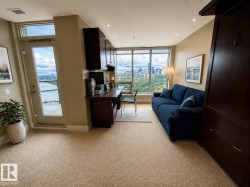 Light beige carpeting with dark wood-finish built-in cabinetry, an integrated desk, and floor-to-ceiling windows - 