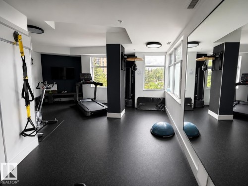 Dedicated fitness space featuring rubber flooring, large windows, recessed lighting, and mirrored wall - #1201 10035 Saskatchewan Dr Nw, Edmonton, AB - Indoor Photo Showing Gym Room