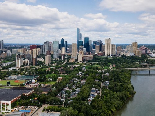 Expansive urban landscape featuring a prominent cityscape, a tree-lined river, a bridge structure, and residential areas - #1201 10035 Saskatchewan Dr Nw, Edmonton, AB - Outdoor With View