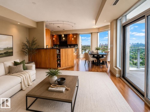 Hardwood flooring, wood-finish cabinetry, an integrated kitchen island, a built-in cooktop with an overhead hood, and floor-to-ceiling sliding glass doors - #1201 10035 Saskatchewan Dr Nw, Edmonton, AB - Indoor Photo Showing Living Room