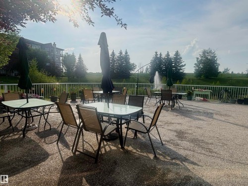 Expansive patio featuring a gravel-finish surface and white railing - #202 8802 Southfort Dr, Fort Saskatchewan, AB - Outdoor
