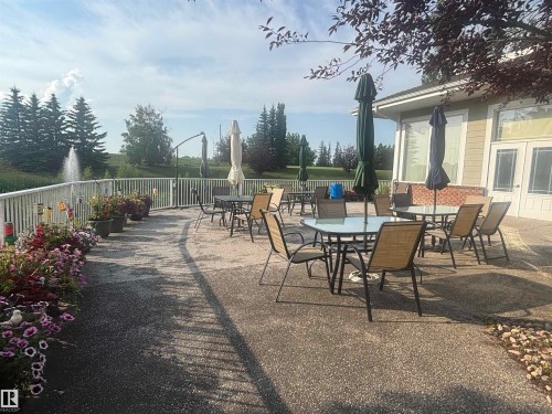 Expansive outdoor patio with a textured concrete surface - #202 8802 Southfort Dr, Fort Saskatchewan, AB - Outdoor With Deck Patio Veranda