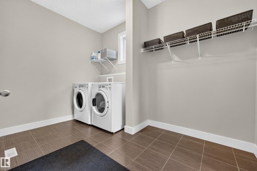 Tile flooring, white baseboards, and neutral wall paint - 1323 158 Street Sw, Edmonton, AB - Indoor Photo Showing Laundry Room