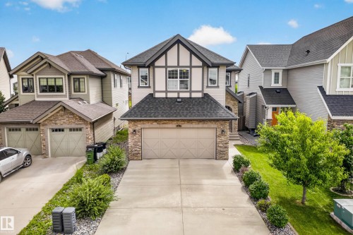 Two-story residence featuring a two-car garage, stone and siding exterior, gabled roofline, and a concrete driveway - 1323 158 Street Sw, Edmonton, AB - Outdoor With Facade
