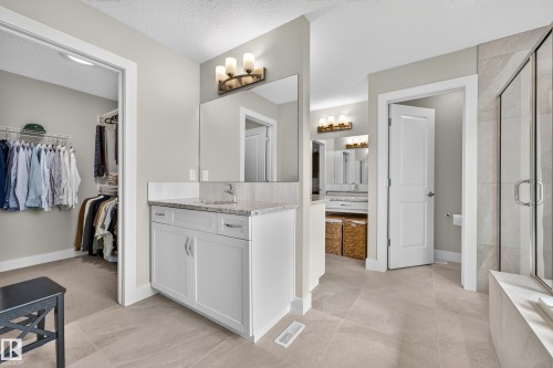 White vanity with a granite-style countertop and undermount sink - 1323 158 Street Sw, Edmonton, AB - Indoor
