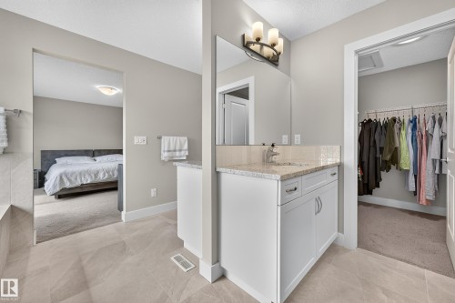 Single vanity with a light-toned countertop, under-mount sink, and dual-handle faucet - 1323 158 Street Sw, Edmonton, AB - Indoor