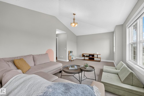Vaulted ceiling with an attached light fixture, multiple windows, and light gray wall paint - 1323 158 Street Sw, Edmonton, AB - Indoor Photo Showing Living Room