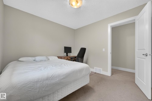Neutral wall paint, carpeted flooring, white trim, solid core interior door, and a flush mount ceiling light - 1323 158 Street Sw, Edmonton, AB - Indoor Photo Showing Bedroom