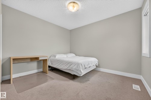 Neutral wall color, wall-to-wall carpeting, recessed window, ceiling-mounted light fixture, white trim - 1323 158 Street Sw, Edmonton, AB - Indoor Photo Showing Bedroom