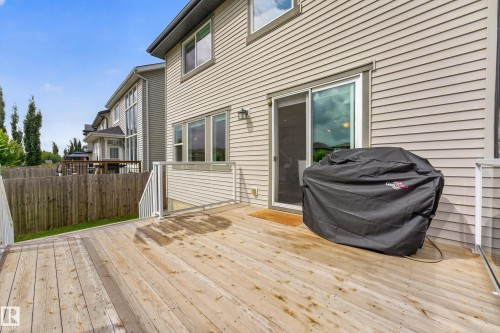 Spacious exterior deck with wood flooring and clear panel railings, featuring a sliding glass door and multiple windows - 1323 158 Street Sw, Edmonton, AB - Outdoor With Deck Patio Veranda With Exterior