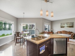 Kitchen island with dual stainless steel sinks, granite-style countertop, and integrated dishwasher - 