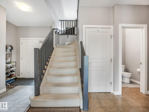 Carpeted staircase with dark wood-finish railings, recessed lighting, and tile flooring in the entry - 1478 37B Avenue Nw, Edmonton, AB - Indoor Photo Showing Other Room