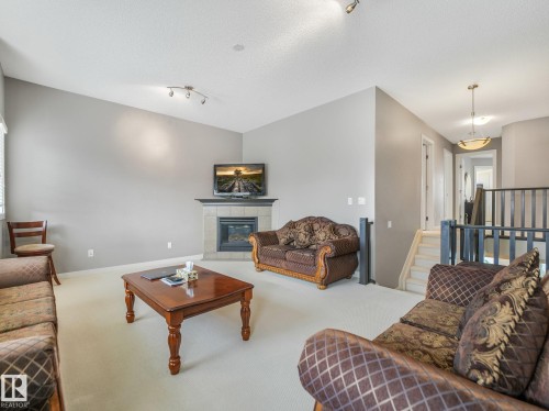 Living area featuring a gas fireplace with a tiled surround, a vaulted ceiling, and recessed lighting - 1478 37B Avenue Nw, Edmonton, AB - Indoor Photo Showing Living Room With Fireplace