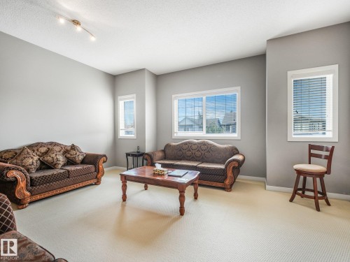Expansive room featuring light-colored carpeting, multiple windows, and a track lighting fixture - 1478 37B Avenue Nw, Edmonton, AB - Indoor Photo Showing Living Room