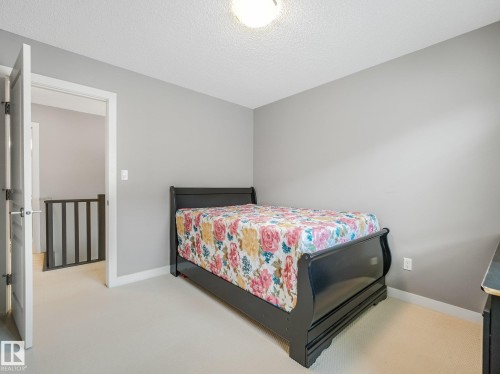 Neutral wall paint, light-colored carpeting, white trim, and a contemporary ceiling light fixture - 1478 37B Avenue Nw, Edmonton, AB - Indoor Photo Showing Bedroom