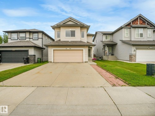 Two-story property featuring light-colored siding, a front-facing attached garage, and a concrete driveway - 1478 37B Avenue Nw, Edmonton, AB - Outdoor With Facade