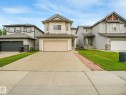 Two-story property featuring light-colored siding, a front-facing attached garage, and a concrete driveway - 1478 37B Avenue Nw, Edmonton, AB  - Outdoor With Facade 