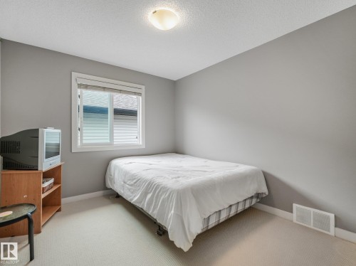 Window with blinds and white trim, light gray painted walls, and light-toned carpet flooring - 1478 37B Avenue Nw, Edmonton, AB - Indoor Photo Showing Bedroom