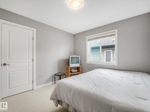 Neutral gray walls, white painted trim, white panel door, carpeted flooring, and a single window - 1478 37B Avenue Nw, Edmonton, AB - Indoor Photo Showing Bedroom