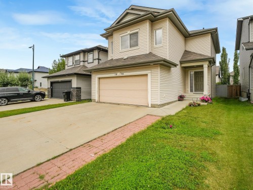 Two-story exterior with light-colored siding, a covered front entry, and an attached two-car garage - 1478 37B Avenue Nw, Edmonton, AB - Outdoor