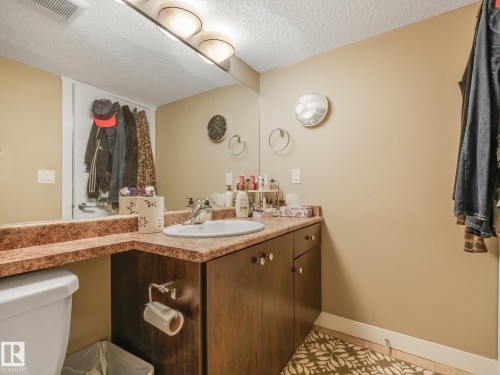 Vanity with an integrated sink, broad wall mirror, and cabinet storage - 1478 37B Avenue Nw, Edmonton, AB - Indoor Photo Showing Bathroom