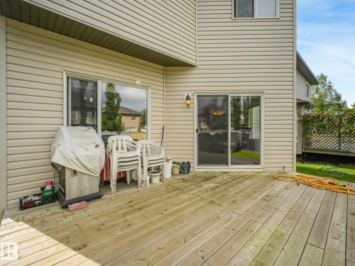 Expansive wood deck with a sliding glass door and an exterior light fixture - 1478 37B Avenue Nw, Edmonton, AB - Outdoor With Deck Patio Veranda With Exterior