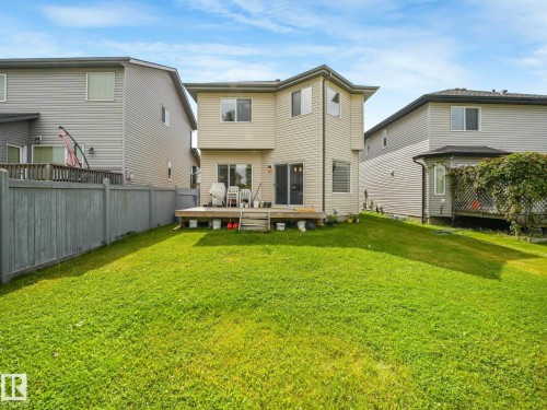 Expansive backyard featuring a manicured lawn, a wooden deck, and a privacy fence - 1478 37B Avenue Nw, Edmonton, AB - Outdoor With Exterior