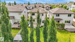 Rear exterior with a multi-level wood deck, a patio area, and a lush green lawn - 