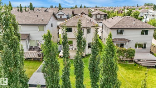 Rear exterior with a multi-level wood deck, a patio area, and a lush green lawn - 1478 37B Avenue Nw, Edmonton, AB - Outdoor