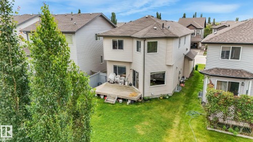 Expansive backyard featuring a manicured lawn, a large wood deck, and mature perimeter trees - 1478 37B Avenue Nw, Edmonton, AB - Outdoor
