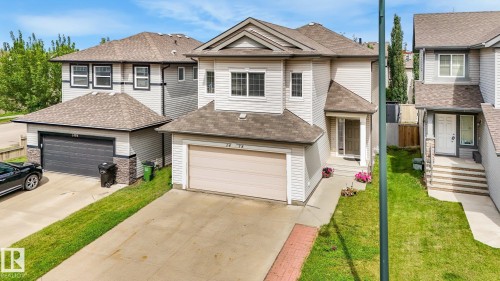 Two-story residence featuring light-toned siding and a brown shingle roof - 1478 37B Avenue Nw, Edmonton, AB - Outdoor With Facade